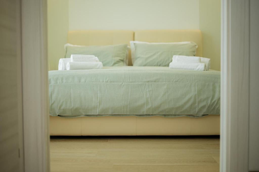 a bedroom with a bed with white sheets and pillows at In centro apartment in Palermo