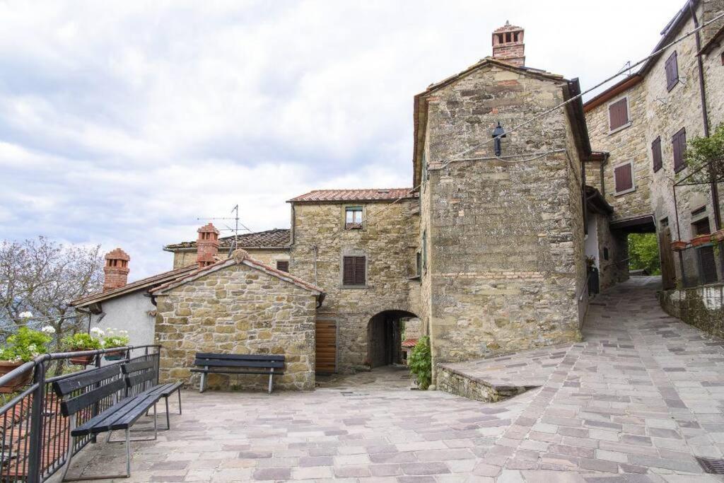 un edificio de piedra con un banco delante en Casa di Adele, en Pratovecchio