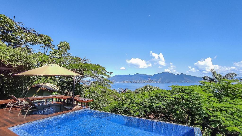 a swimming pool with a view of the ocean at Casa com piscina e vista para o mar em Ilhabela in Ilhabela
