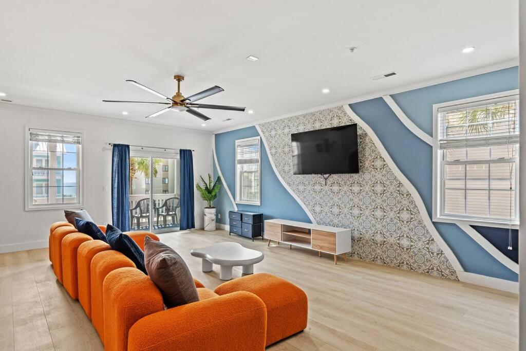 a living room with an orange couch and a tv at Luxurious Home with Theatre Room in Myrtle Beach