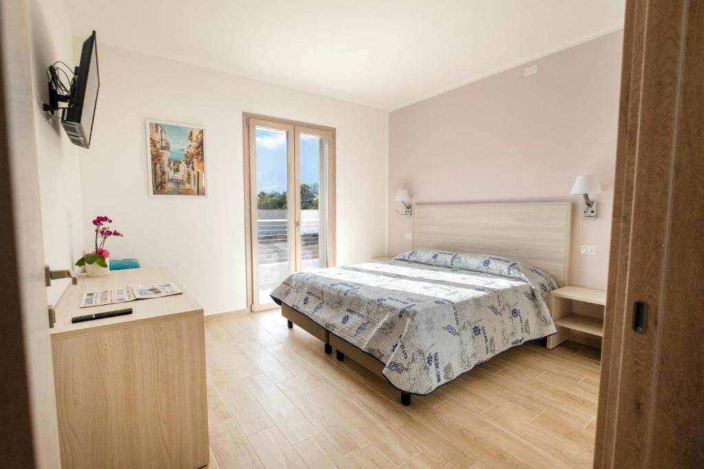 a bedroom with a bed and a desk at Villa Solymar in Alghero