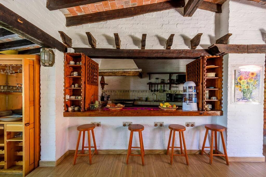 バジェ・デ・ブラボにあるCuarto Privado en Hostal Para 2 Personas Valleのキッチン(バースツール2脚、カウンター付)