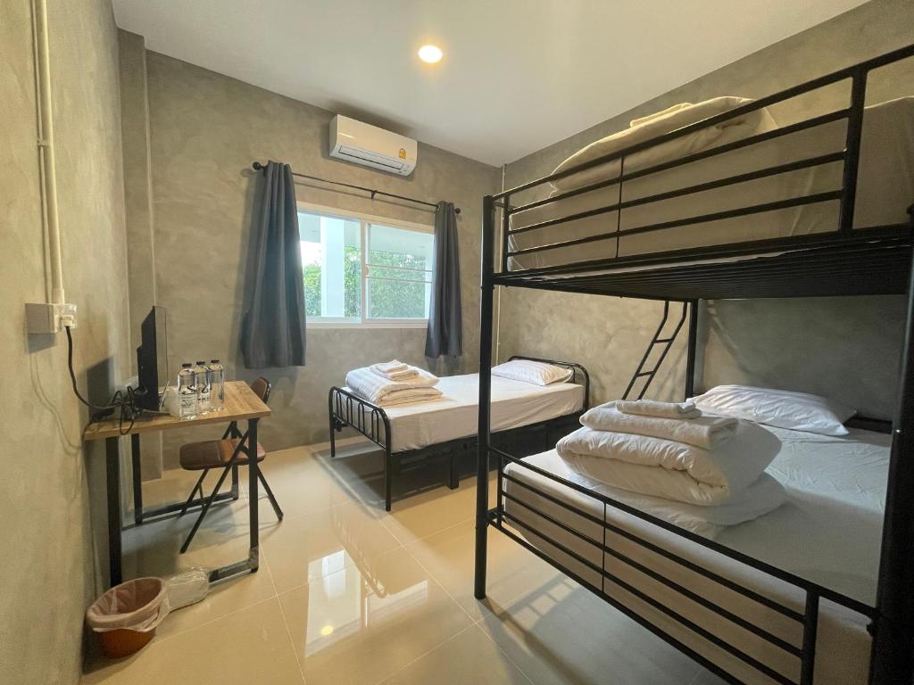 a room with two bunk beds and a window at Soysiam in Ban Huai Lat