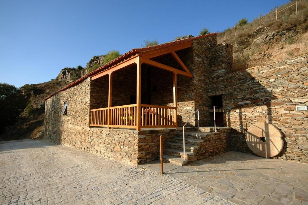 a stone building with a wooden porch on it at Casa do Moleiro in Mirandela