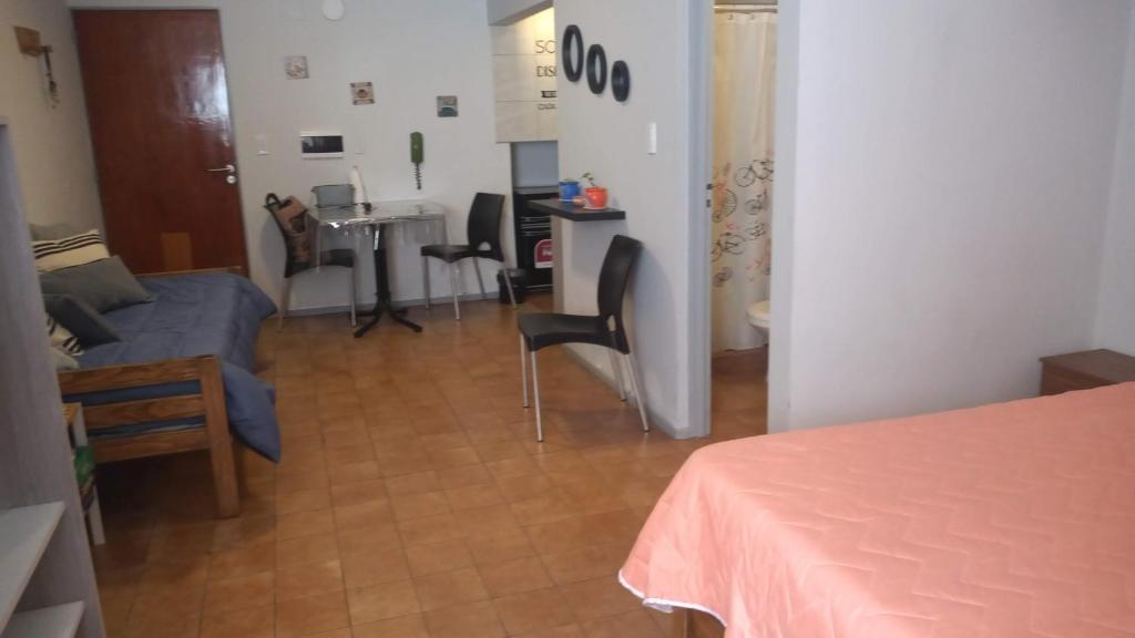 El Racimo, dpto en Ciudad de Mendoza في ميندوزا: غرفة مع غرفة معيشة مع طاولة وأريكة