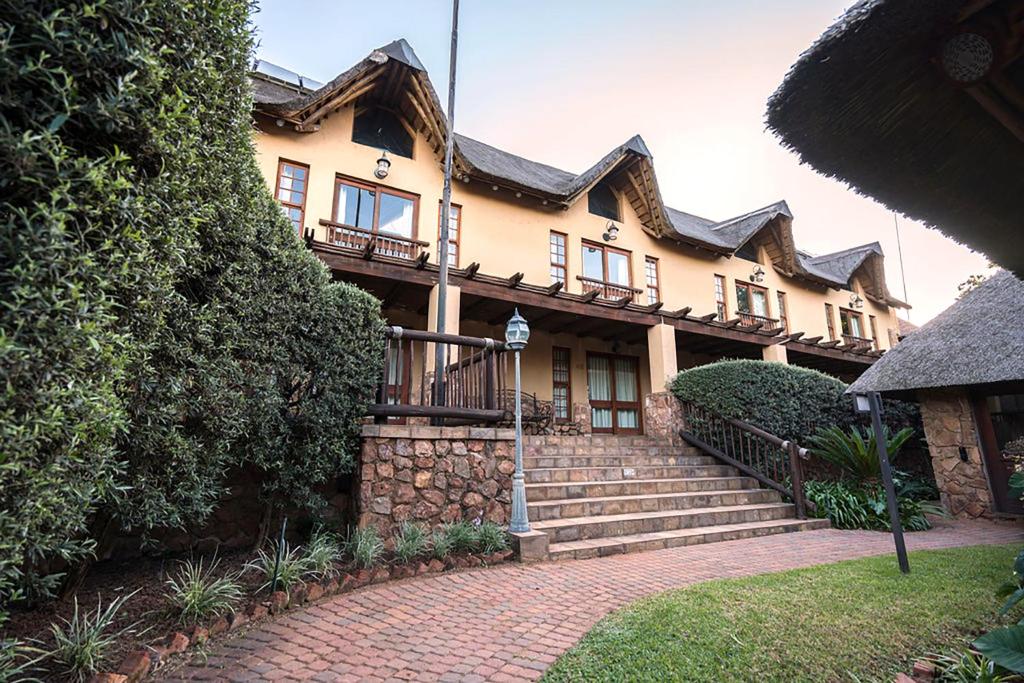 una casa grande con un camino de ladrillo delante de ella en Isiphiwo Village Accommodation Venue and Spa, en Pretoria