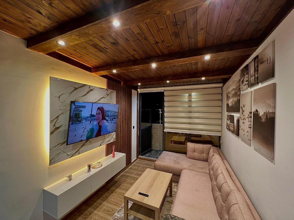ein Wohnzimmer mit einem Sofa und einem TV in der Unterkunft Centrico Tanger Idrissia 4 in Tangier