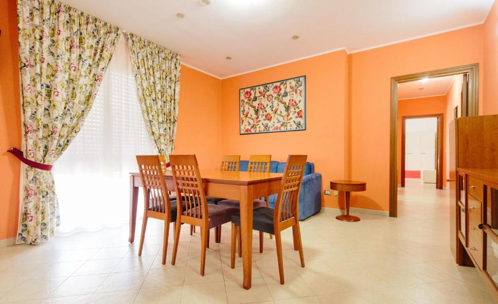 comedor con paredes de color naranja, mesa y sillas en CASA ELENA, en Alghero