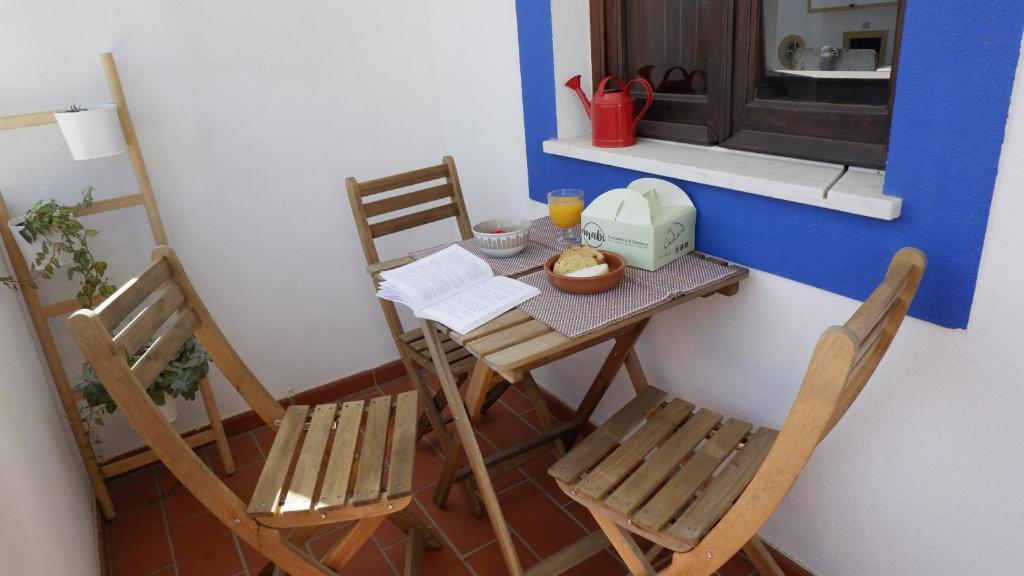 a small table and chairs in a small kitchen at Casa BARCA DO SOL in Vila Nova de Milfontes