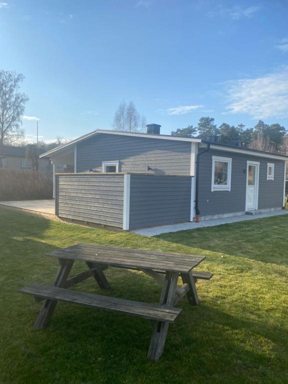 un banco de picnic en el césped frente a una casa en Monsunen, en Sölvesborg