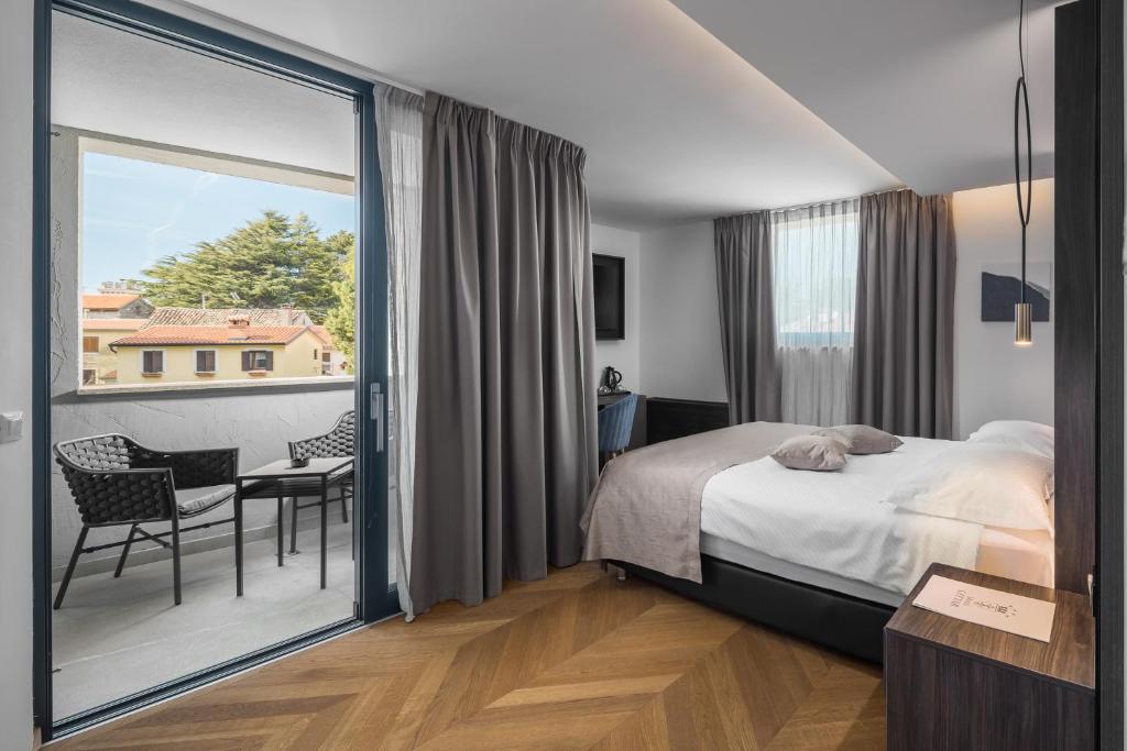 a hotel room with a bed and a balcony at Hotel Cittar in Novigrad Istria