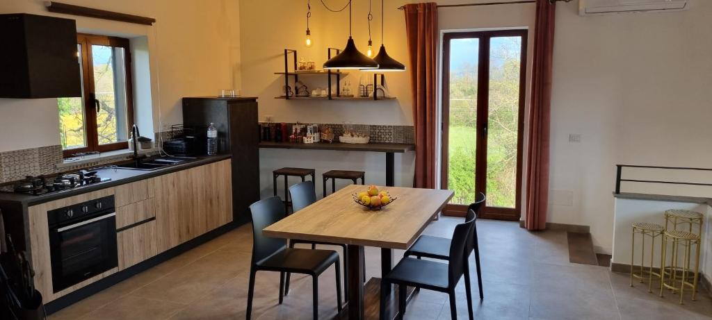 kuchnia z drewnianym stołem i krzesłami w kuchni w obiekcie Oltre la Siepe Apartment w mieście Nepi