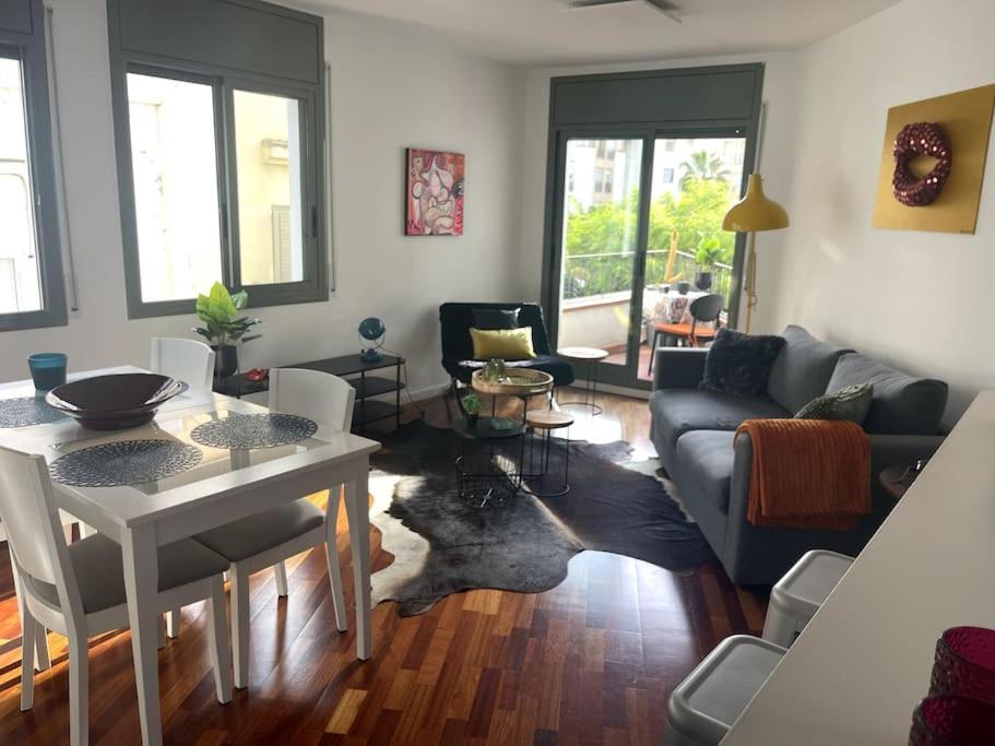 uma sala de estar com uma mesa e um sofá em Pure Bliss Apartment Sitges em Sitges