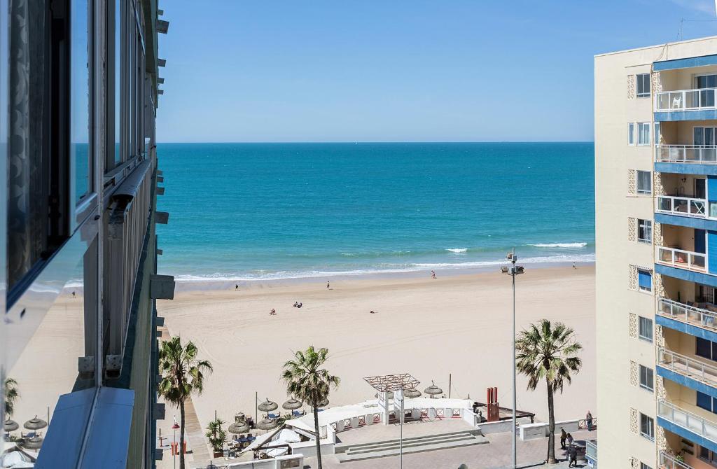 a view of a beach from a building at Playa Victoria Paseo Marítimo 3 Rooms in Cádiz