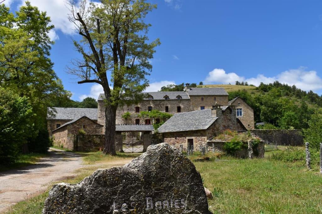 ein altes Steinhaus mit einem Baum auf einem Hügel in der Unterkunft Les Distinguées -Aux Bories de Prévinquières in Recoules-Prévinquières