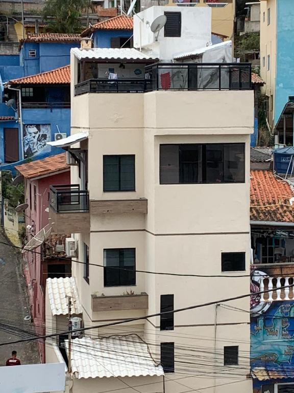 a tall white building with balconies on top of it at Casa triplex com cobertura a 5 minutos da praia in Arraial do Cabo