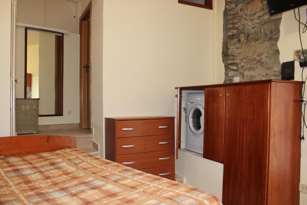 カステッラバーテにあるIl Fascino del Borgoのベッドルーム1室(ベッド1台付)、洗濯機(ドレッサー付)