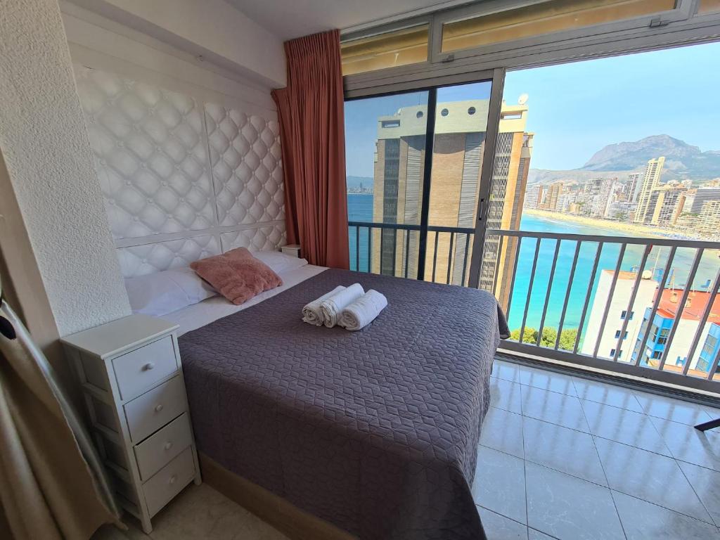 sypialnia z łóżkiem i dużym oknem w obiekcie Agua Mundo studio w mieście Benidorm