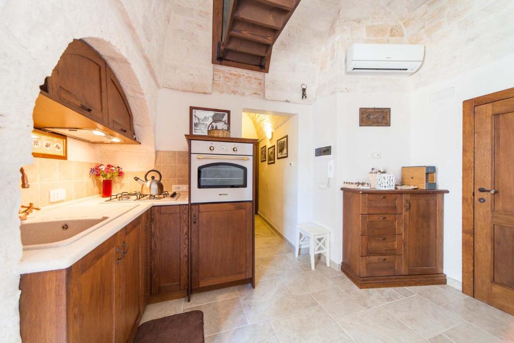 a kitchen with a sink and a stove top oven at La corte di Ercole in Alberobello