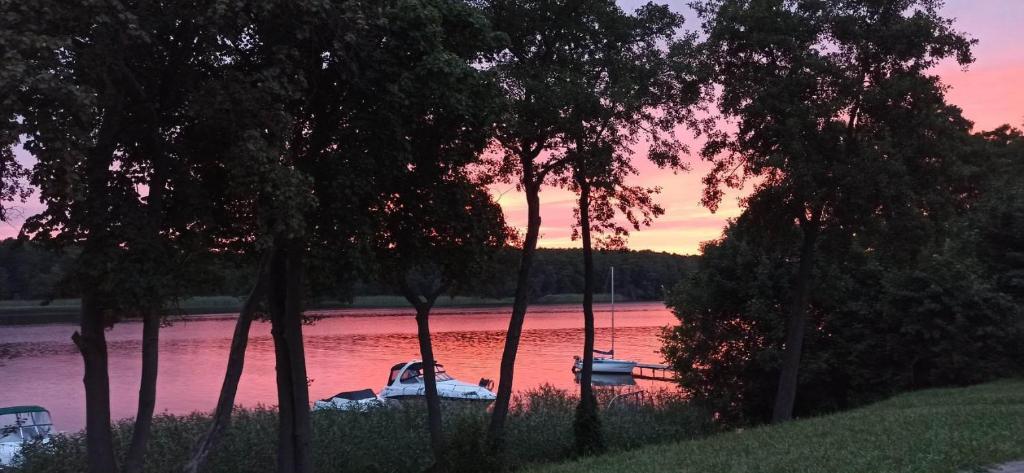 un bateau est amarré sur une rivière au coucher du soleil dans l'établissement u Tymka, à Iława