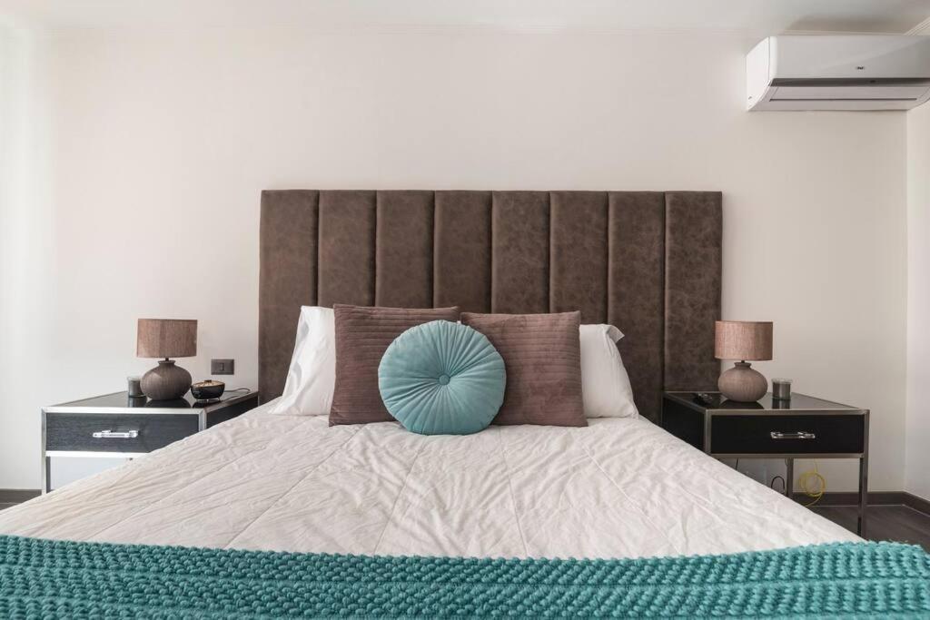 um quarto com uma cama grande e uma almofada azul em Hermoso Apartamento en el Casco Histórico de Santiago em Santiago