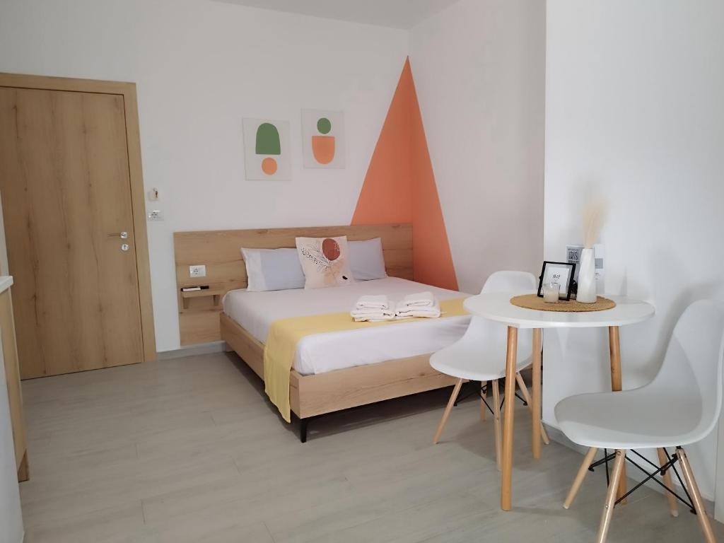 um quarto com uma cama, uma mesa e cadeiras em Iris Apartments Ksamil em Ksamil