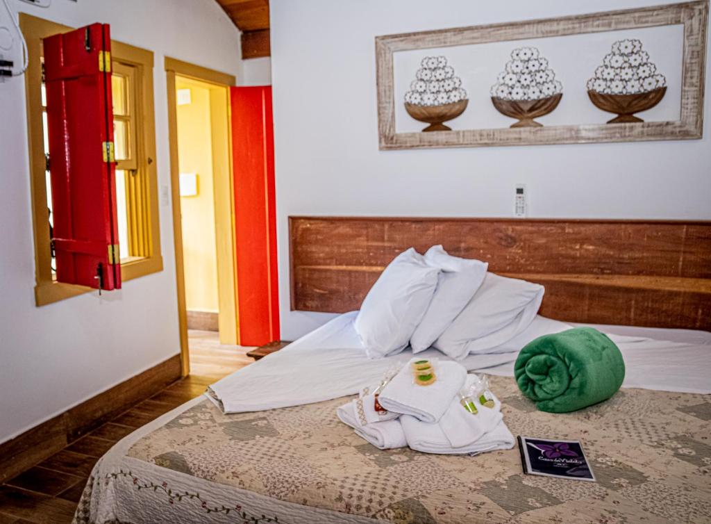 1 dormitorio con 1 cama con sombrero verde en Flats Casa de Violeta, en Tiradentes