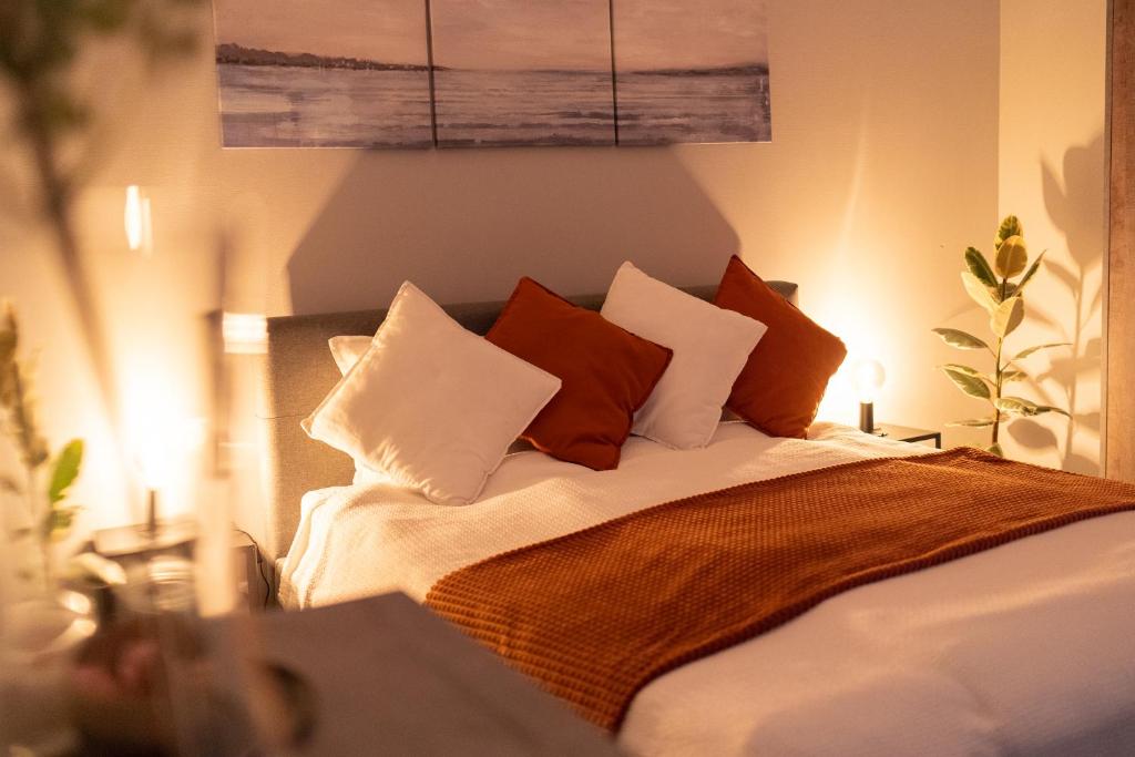 a bed with pillows on it in a room at Piejūras māja skandināvu stilā! Seaside scandi house! in Lapmežciems