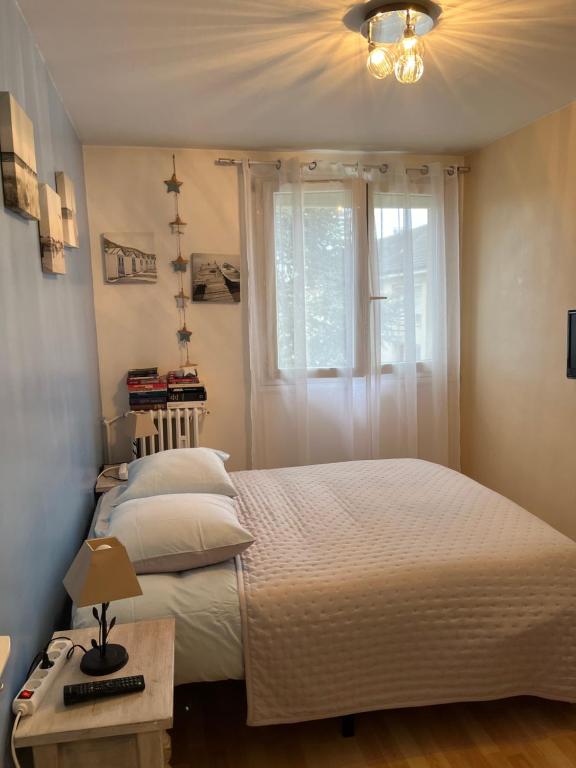 a bedroom with a white bed and a window at Chambre d hote au calme in Brétigny-sur-Orge