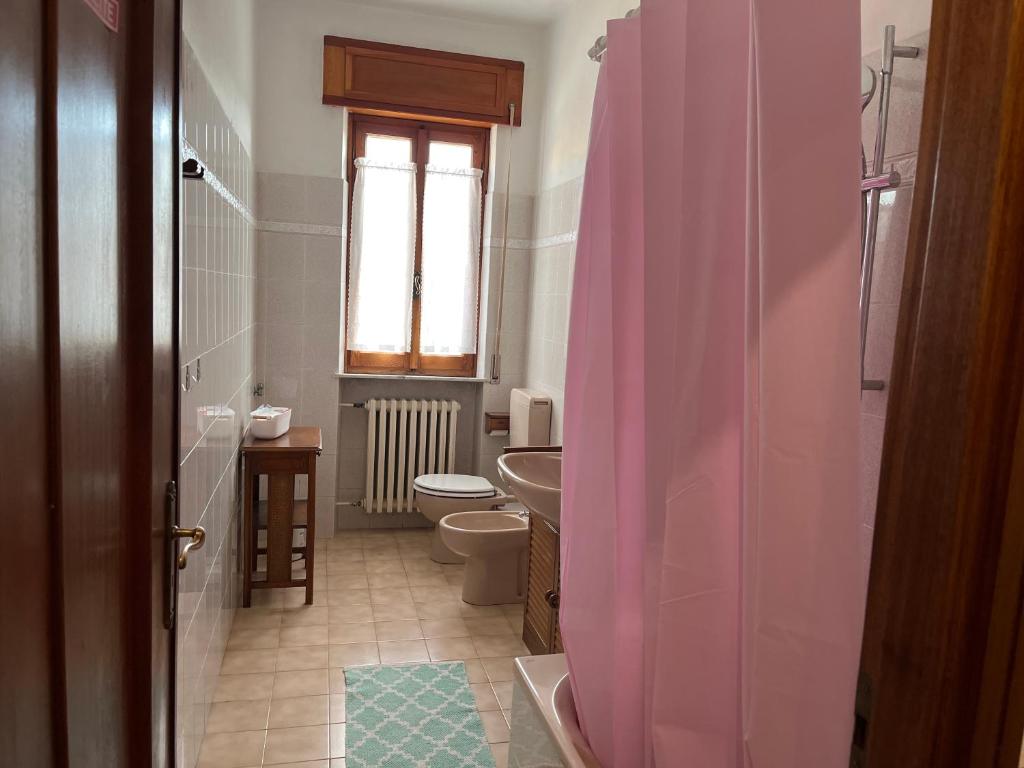 bagno con tenda doccia rosa e servizi igienici di Casa T Bed and Breakfast & Home Restaurant a Tagliolo Monferrato