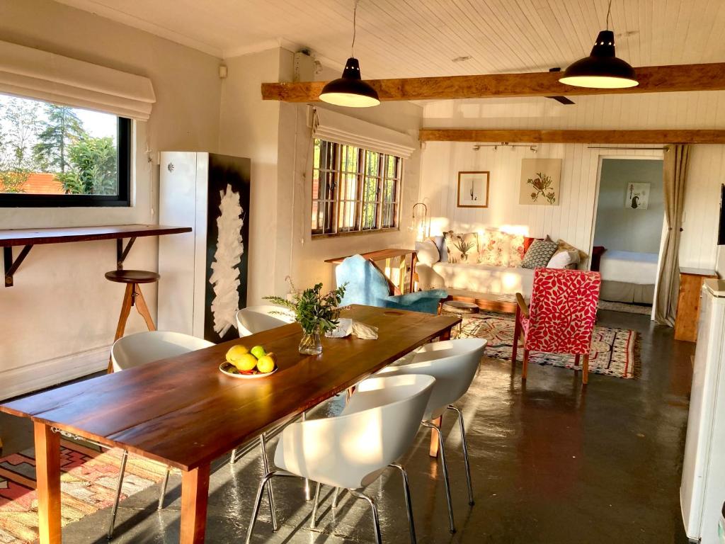 cocina y sala de estar con mesa de madera y sillas en 180 at Mission House, en Curryʼs Post