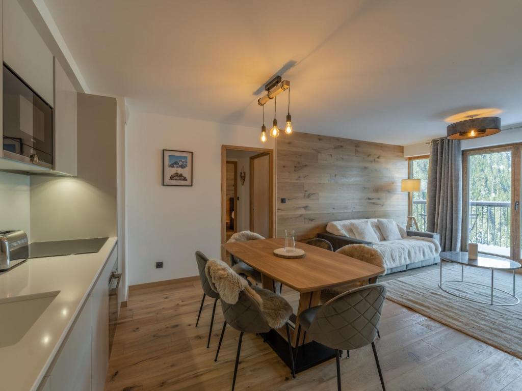 une cuisine et un salon avec une table et des chaises dans l'établissement Appartement Neuf 65m² Courchevel Moriond, 2 Chambres + Cabine, Balcon, Parking Couverts, Skis aux Pieds - FR-1-563-127, à Courchevel