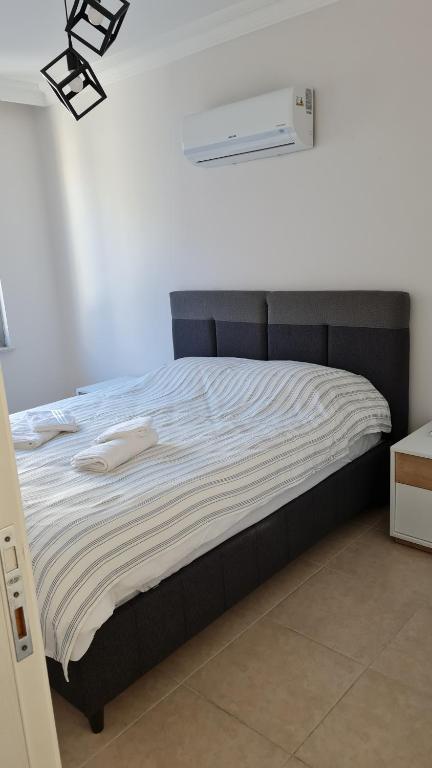 een bed met twee handdoeken in een slaapkamer bij Nimet Aydın Apartmanı in Alanya