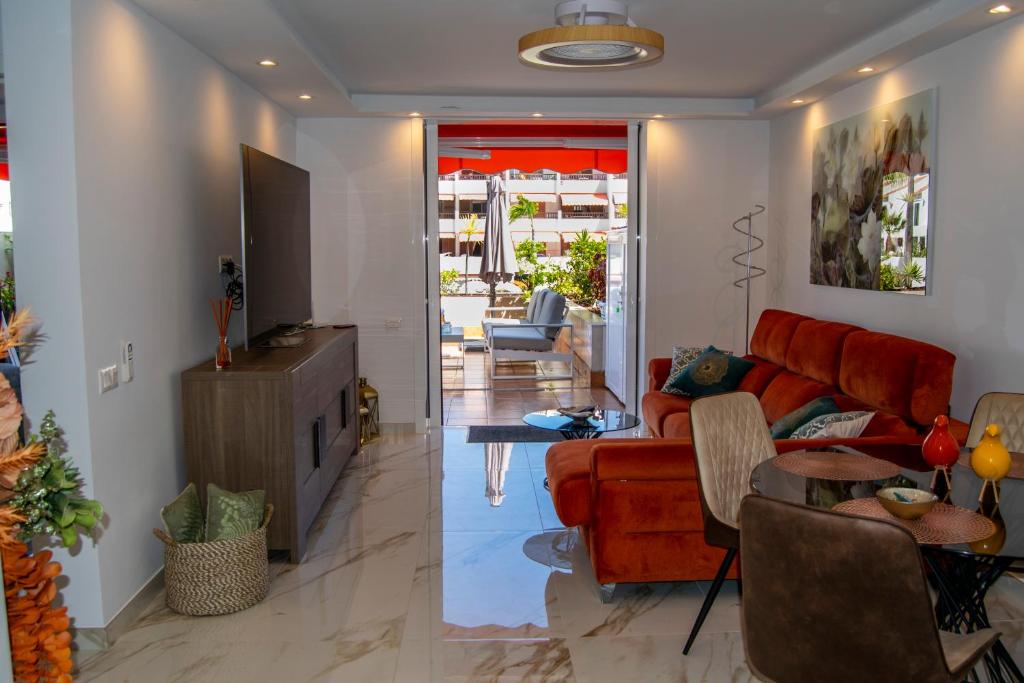 a living room with a red couch and a table at PARQUE SANTIAGO I Stunning brand new apt 2 bedroom Playa de las Américas in Playa de las Americas