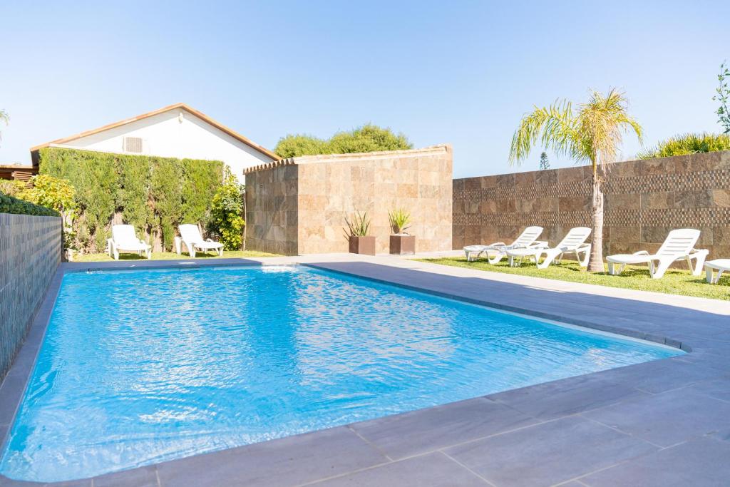 una piscina en un patio con sillas y una casa en Apartamento Jibazahora B1, en Zahora