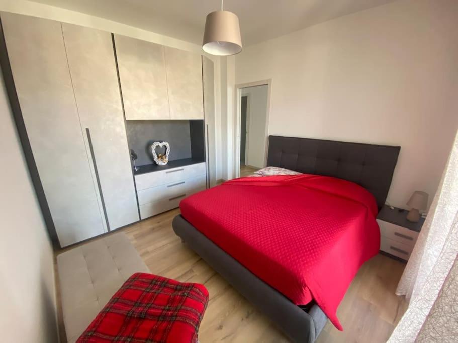 a bedroom with a red bed and white cabinets at Il Giardino dei Ciliegi in Colico