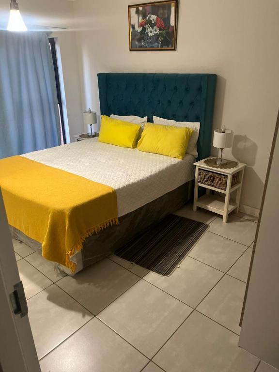 een slaapkamer met een groot bed met gele kussens bij The blyde crystal lagoon in Pretoria