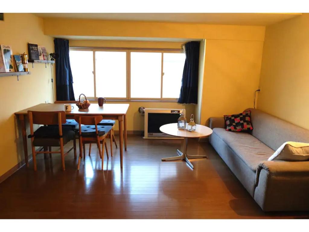 a living room with a couch and a table at Asahikawa Henshushitsu - Vacation STAY 13647 in Asahikawa