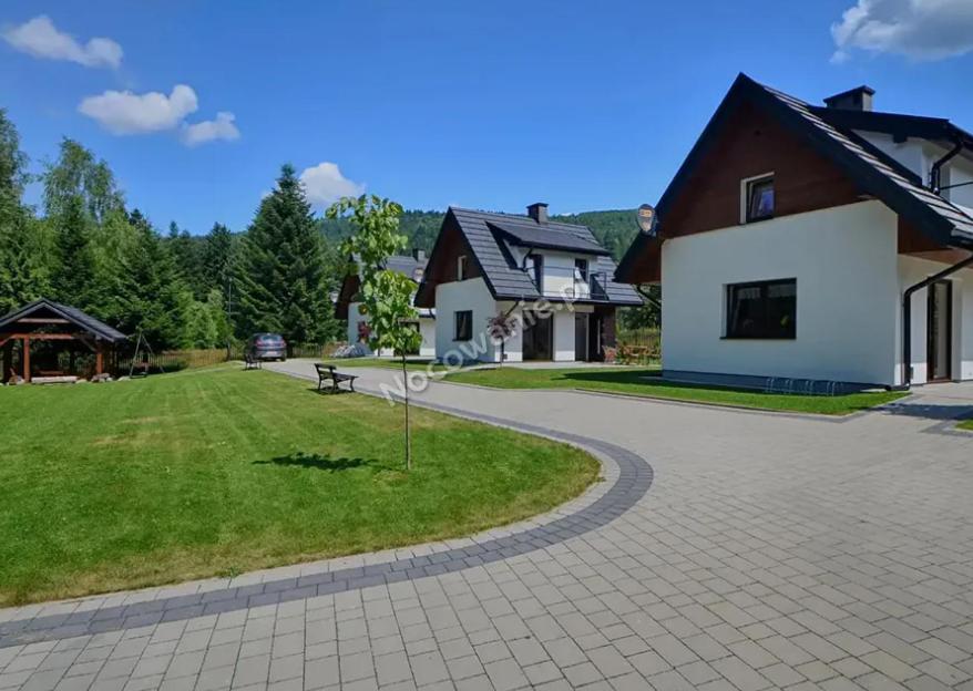 a house with a path leading to a yard with a park at Domki Letniskowe SOBALSKI in Zawoja