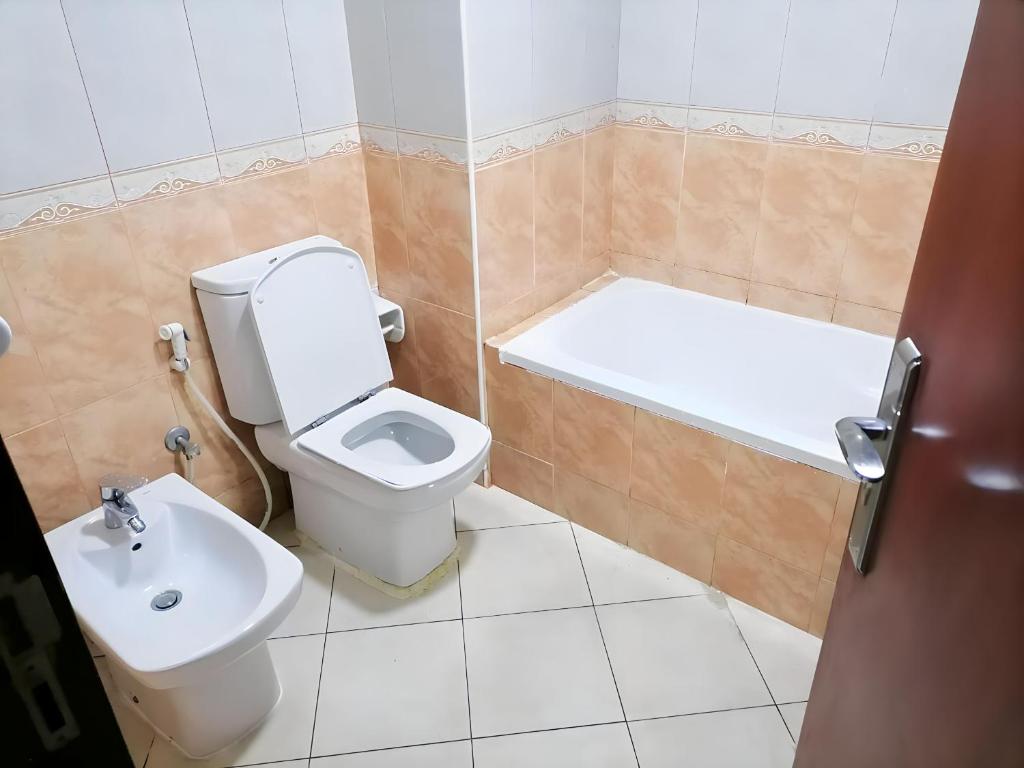 y baño con aseo, bañera y lavamanos. en MBZ - Relax Room in Unique Flat, en Abu Dabi