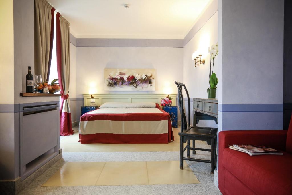 een slaapkamer met een bed, een tafel en een stoel bij NaturalMente Wine Resort in Agliano Terme