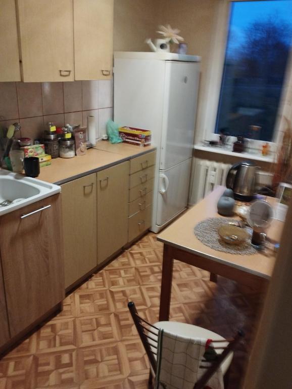 una cucina con un tavolo e un frigorifero bianco di Apartament Zielona a Gdynia