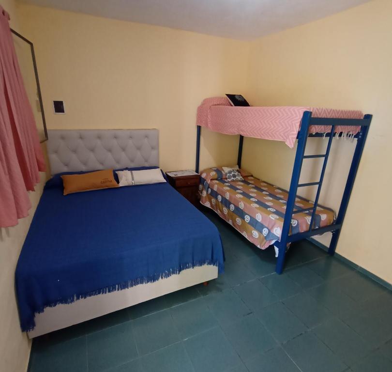 a bedroom with two bunk beds and a chair at TU LUGAR in Villa Cura Brochero