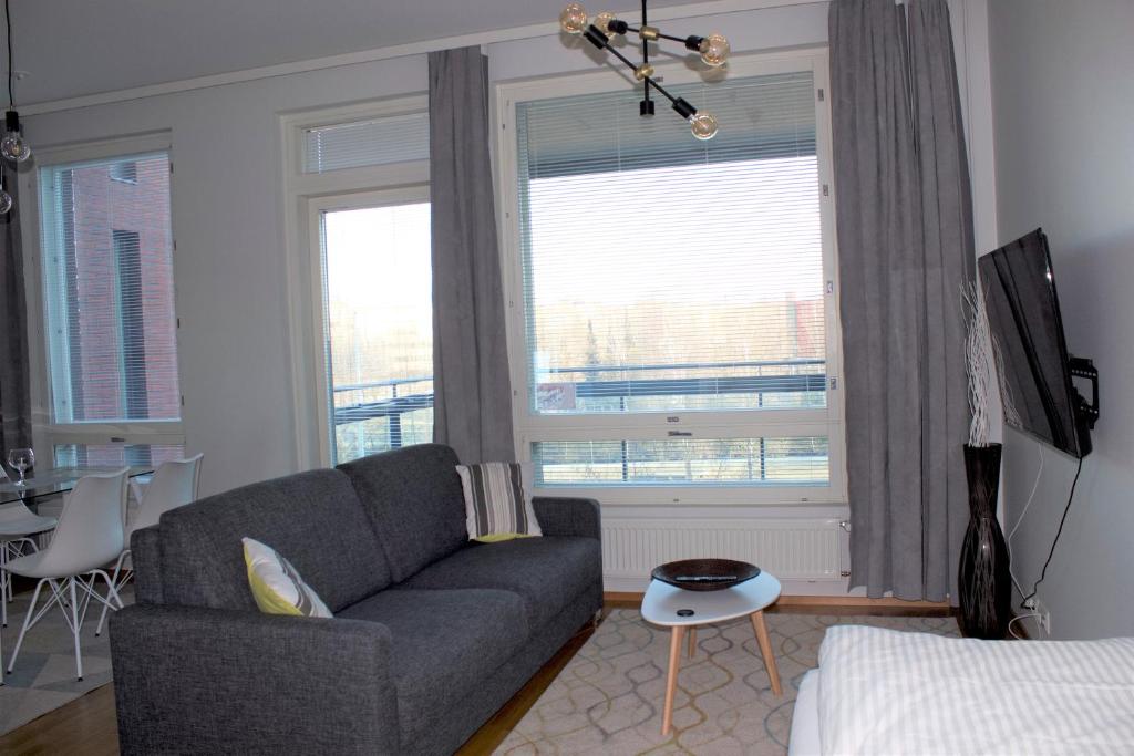 a living room with a couch and a large window at MM City Apartment Ratina Close to Arena in Tampere