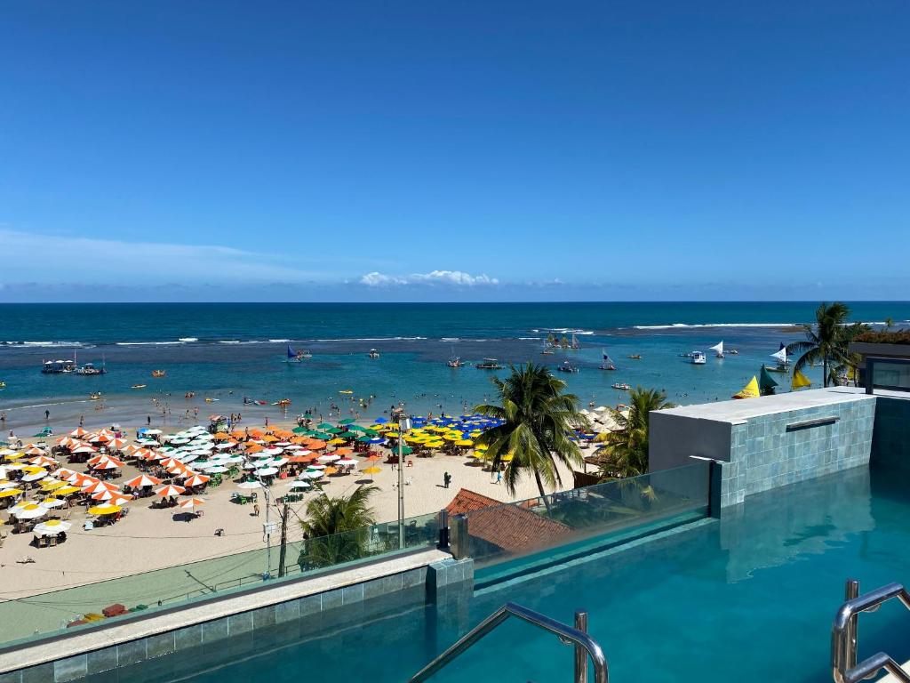 uma vista para uma praia com uma piscina em Flat mar Porto de Galinhas em Porto de Galinhas