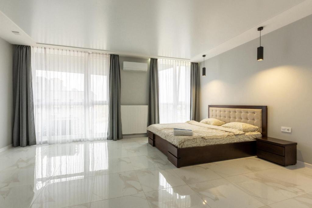 een slaapkamer met een bed en een groot raam bij VIP Apartment near Center in Lviv