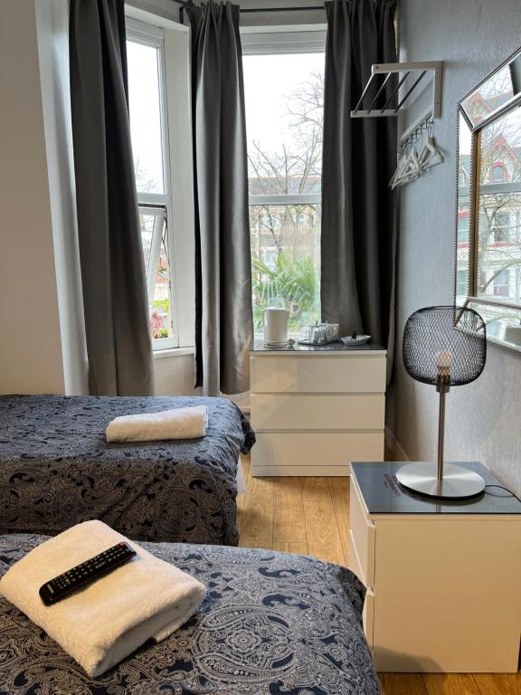 1 dormitorio con 2 camas y ventana en parklane guest house en Cardiff
