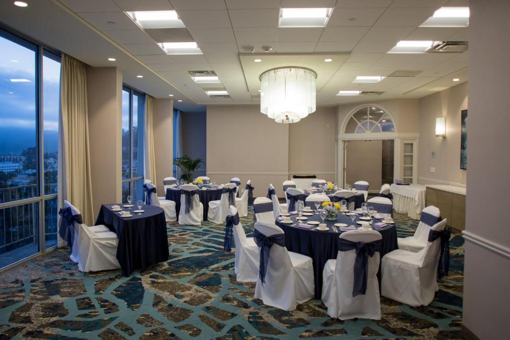 a banquet room with tables and chairs and a chandelier at Crowne Plaza Hotel Ventura Beach, an IHG Hotel in Ventura