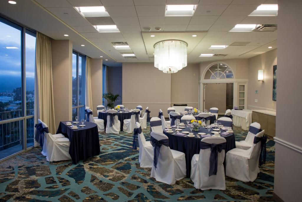 uma sala de banquetes com mesas e cadeiras e um lustre em Crowne Plaza Hotel Ventura Beach, an IHG Hotel em Ventura