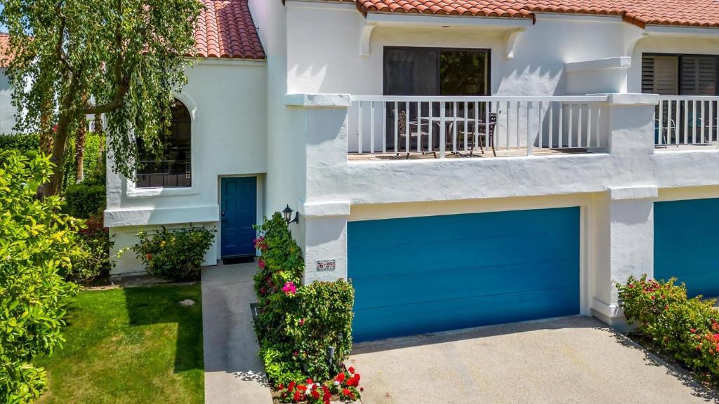 a house with blue garage doors and a balcony at TV202 Modern 2 Bedroom Tennis Villa at LQ Resort in La Quinta